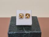 a close up of a pair of earrings sitting on top of a marble block