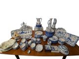 une table sur laquelle sont disposées de nombreuses pièces de vaisselle bleue et blanche