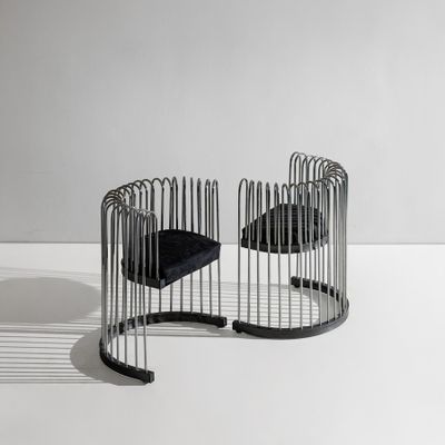deux chaises noires placées l'une à côté de l'autre sur une surface blanche