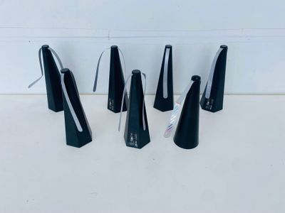four black metal bells sitting on top of a white counter