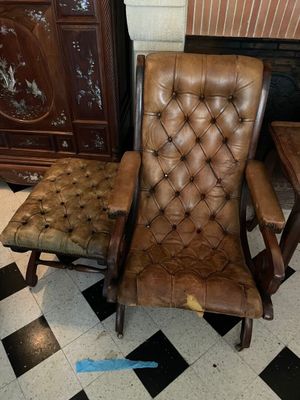 a brown leather chair sitting in a room with a black and white checkered floor