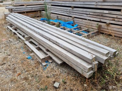 a pile of wood sitting on the ground next to a pile of blue bags