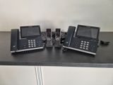 trois téléphones posés sur une table, avec un autre téléphone posé dessus