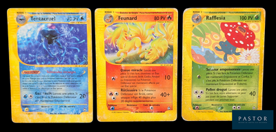 trois cartes Pokémon présentant des motifs différents sur un fond noir