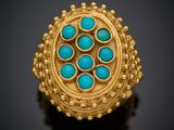 une bague en or sertie de turquoises sur un fond noir