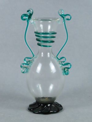 an image of a glass vase with a green handle