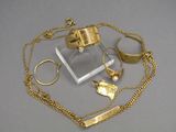 a necklace, ring, bracelet, and ring holder on a table