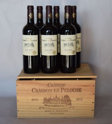 quatre bouteilles de vin rouge dans une caisse en bois posée sur une table