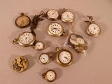 many different types of pocket watches on the table