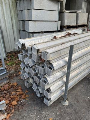 un tas de tuyaux métalliques posés devant un bâtiment