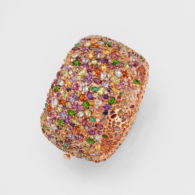 a close up of a gold ring with multi colored stones