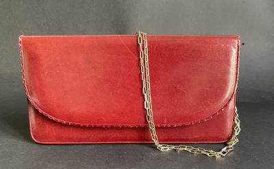 a red leather clutch bag with a gold chain strap