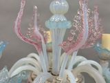 a glass chandelier that has a bunch of flowers on it
