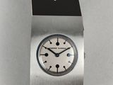 a close up of a watch on a white surface