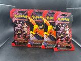 trois paquets de cartes à collectionner Pokémon posés sur une surface noire