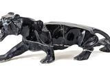 une statue noire représentant un tigre sur fond blanc