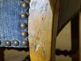 a close up of a wooden chair with a blue upholstered seat