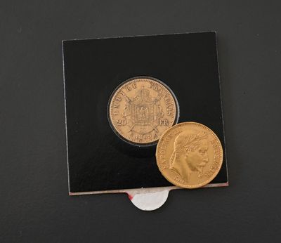 two gold coins sitting next to each other on a black surface