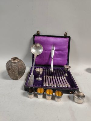 un étui violet contenant des couverts, posé sur une surface blanche