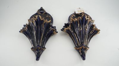 two blue and gold wall sconces on a white background