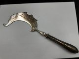a silver spoon with a metal handle on a piece of paper
