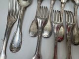 a lot of silver spoons and forks on the table
