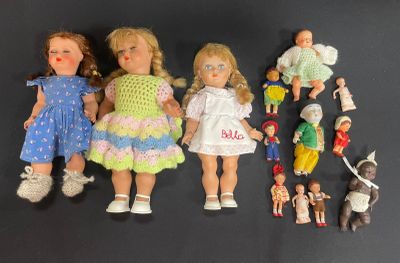 a lot of dolls that are sitting on a black surface
