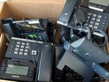 beaucoup de téléphones dans une boîte posée par terre