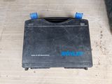an image of a black tool box sitting on top of a wooden floor