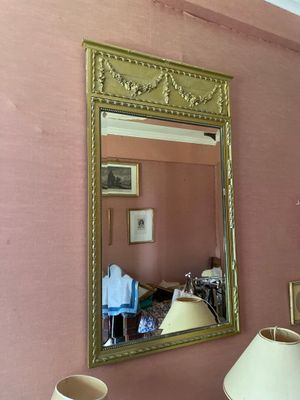 un miroir accroché au mur au-dessus d'une lampe dans une pièce
