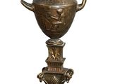 a statue of a man holding a vase on top of it