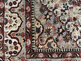 an antique persian rug with a floral design on a blue ground