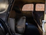 two seats in the back of a car with a brick wall in the background