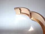 a close up of a gold bracelet with a hole in the middle