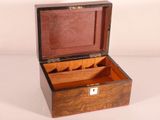 a small wooden box with compartments in it on a white surface