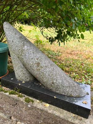 a stone sculpture of a whale sitting on a stone block