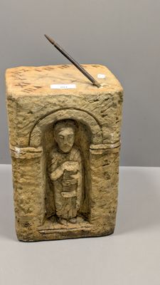statue représentant une personne tenant un couteau, sculptée dans un bloc de pierre