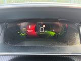 the dashboard of a car with a red and green gauge