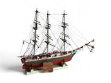 une petite maquette de bateau posée sur une surface blanche
