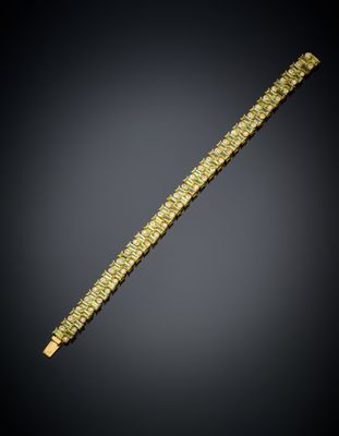 un bracelet en or orné de pierres vertes sur fond noir