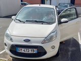 une petite voiture blanche garée dans un parking