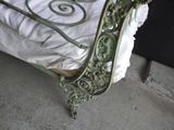 a bed with a metal frame and a white sheet on it