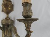 pair of antique brass wall sconces with candle holders on a white background