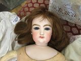 a doll that is sitting on a bed with a pillow