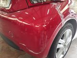 a close up of a red car that is parked in a garage