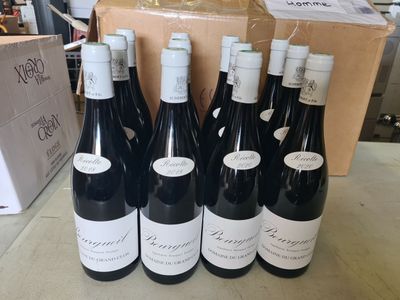 six bouteilles de vin rouge sont alignées sur une table