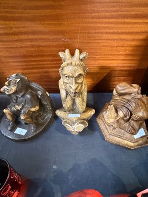 three statues of animals on display in a glass case