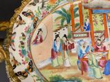 a plate with a painting on it sitting on a table