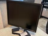 a computer monitor sitting on top of a desk next to a keyboard