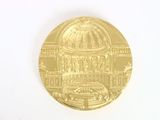 a gold coin with a picture of a building on it